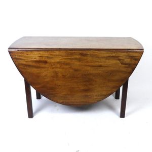 A Georgian mahogany dropside dining table, the oval solid top…