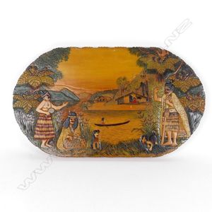 An oval Jane Brenkley carved and painted Maori themed…