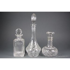 A group of three glass decanters one, ship's shaped diamond cut…