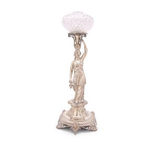 A sterling silver centrepiece. The crystal shade held aloft by…