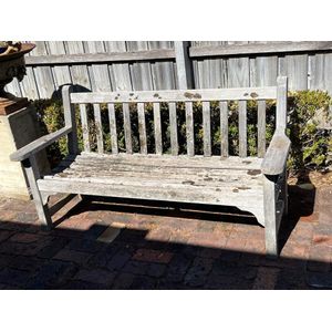 A slatted-teak garden seat with makers label 160 cm wide 84 cm…