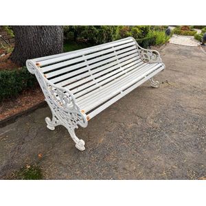 A white-painted slatted wood and cast-iron garden seat, English…