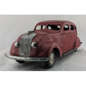 A tin plate red Chrysler Airflow sedan, probably made in Japan,…