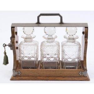 An antique English tantalus set, oak and nickel plate with…