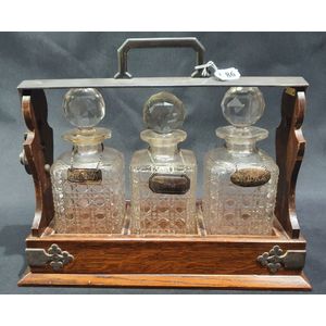 An Edwardian oak tantalus, with silver plated fittings, the…