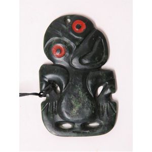 A 20th century Maori pounamu hei tiki, dark green nephrite, red…