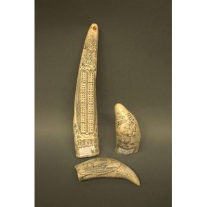 Three pieces of faux scrimshaw, one made into a cribbage board…