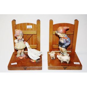 Pair of Goebel Hummel figural bookends with timber gate bases,…