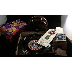 A vintage Bakelite roulette wheel, chips, card shue and cards,…