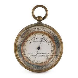 An antique pocket barometer with retailer's details on the dial…