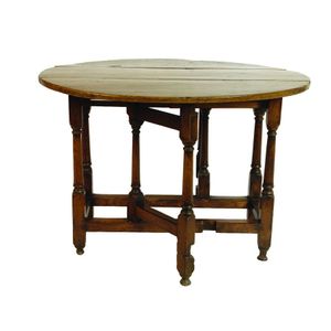 A Georgian oak gate leg table, the plain circular four plank…