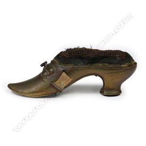 A Victorian brass pin cushion and tape measure, in the form of…