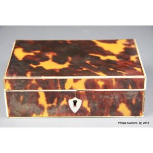 A tortoiseshell lidded box, in striking mottled shades edged…