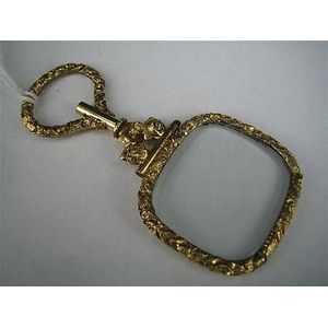 A Victorian rolled-gold Quizzing glass, flower and leaf frame.