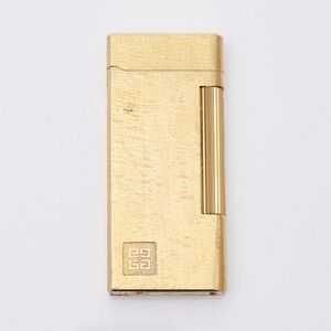 A Givenchy gold plated lighter. Dimensions 6.5 x 3 cm. Not…