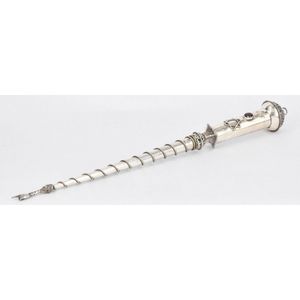 A silver torah yad, inset with an oval facetted red stone,…