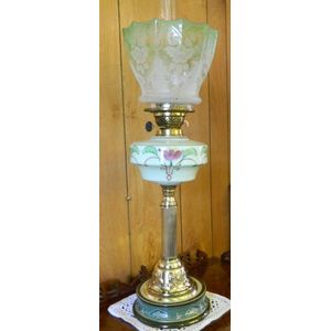 An Art Nouveau oil lamp with green ceramic base and hand…