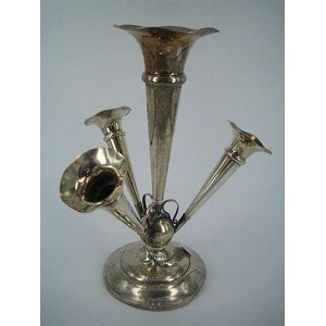 A silver four-trumpet centrepiece with stepped circular base,…