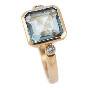 An 18ct gold aquamarine and diamond ring, rub set with an…