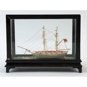 An antique carved bone model ship in case, in the Prisoner of…
