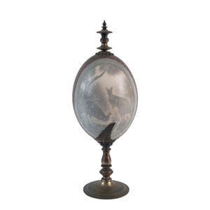 A carved emu egg with kangaroo and emu on turned metal stand,…