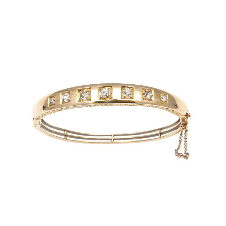 A Victorian gold and diamond bangle, the oval hinged bangle is ...