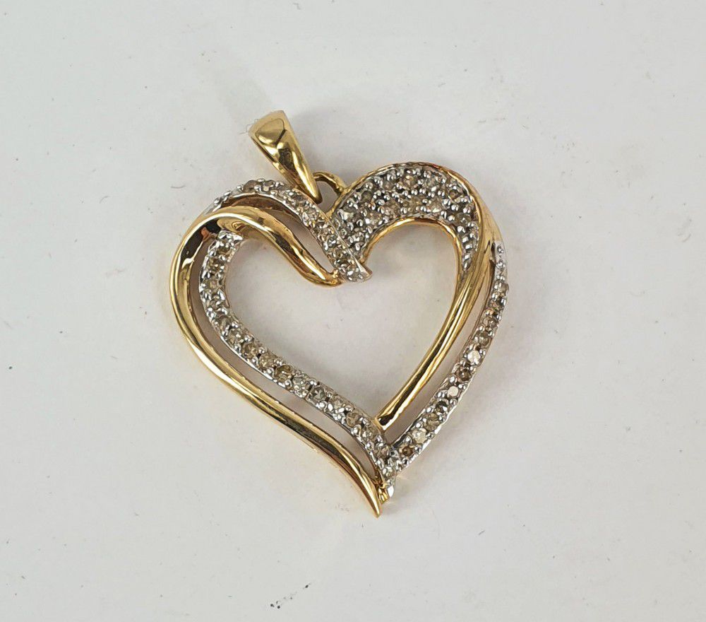 A 9ct gold and diamond love heart pendant. Length 26 mm. Weight ...