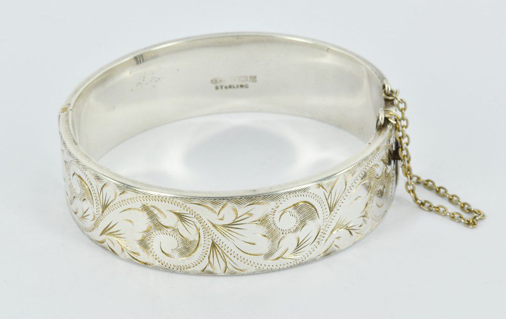 An etched sterling silver hinged bangle, half etched floral ...