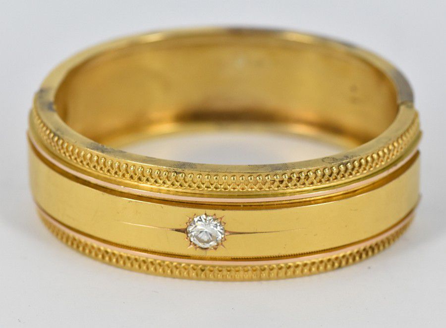 A Victorian gold bangle, the 18 carat yellow gold bangle inset ...