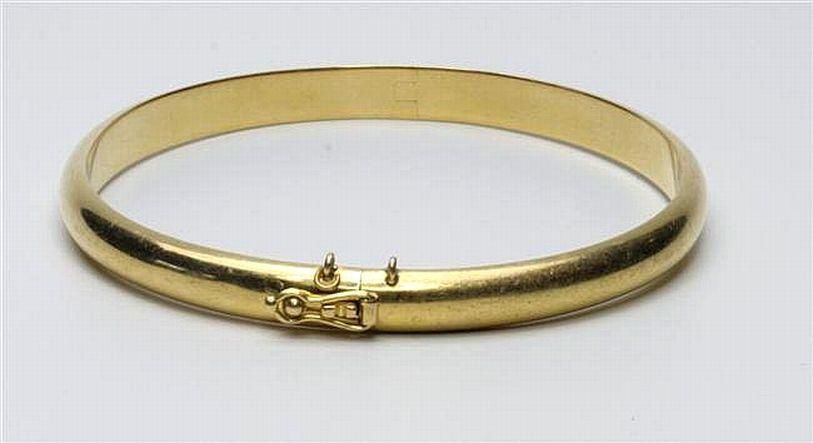An 18ct gold bangle; hinged bangle with box clasp and safety ...